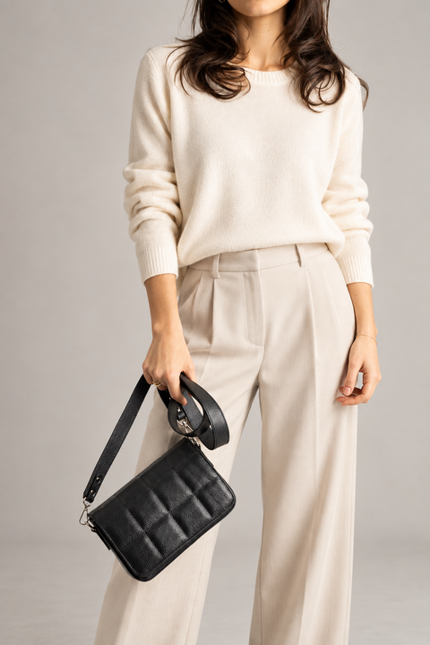 Statement & Texture - quilted leather bag held by a model